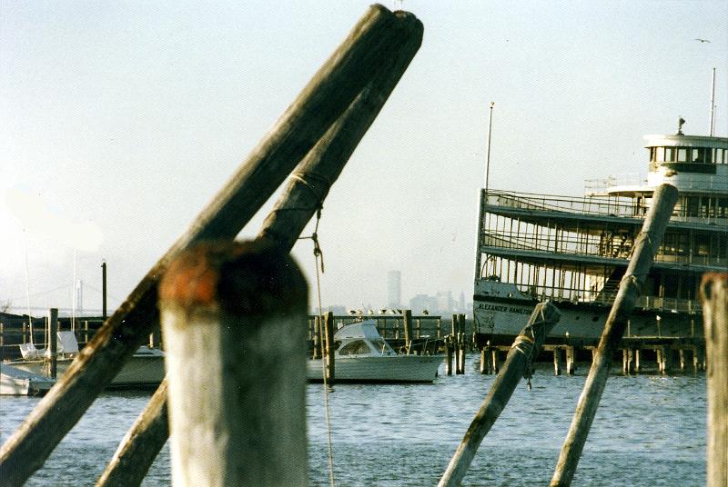 01 You can see the World Trade Towers over the dock.  The ferry is derelict, about to be towed away for scrap.  The site is now a modern commuter ferry terminal.